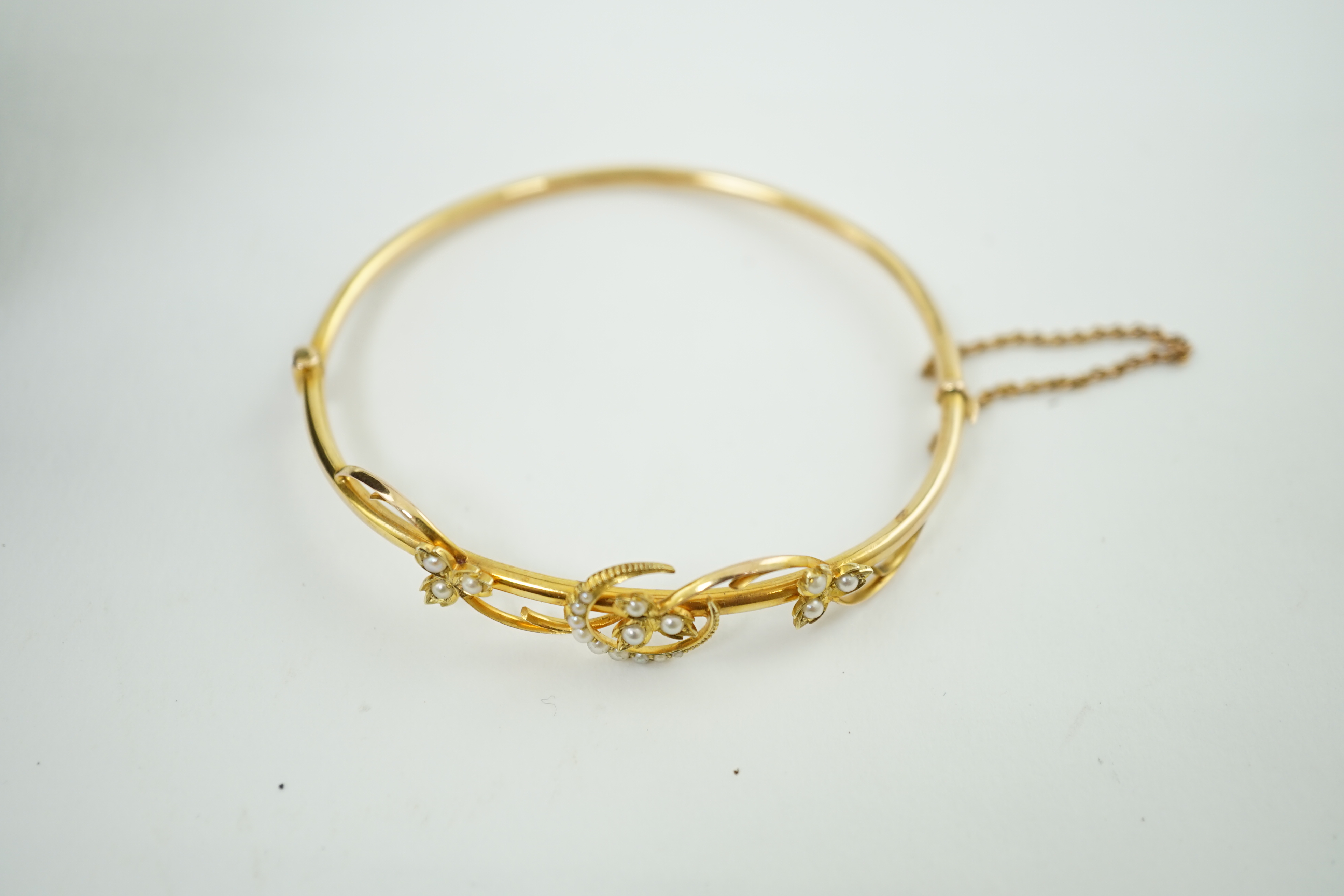 A Victorian 15ct gold and seed pearl set hinged bangle